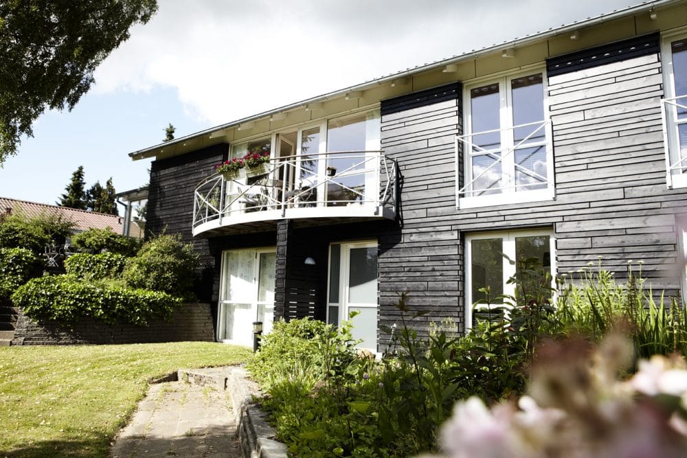 Et hus der er renoveret og beklædt med sorte brædder fra Superwood